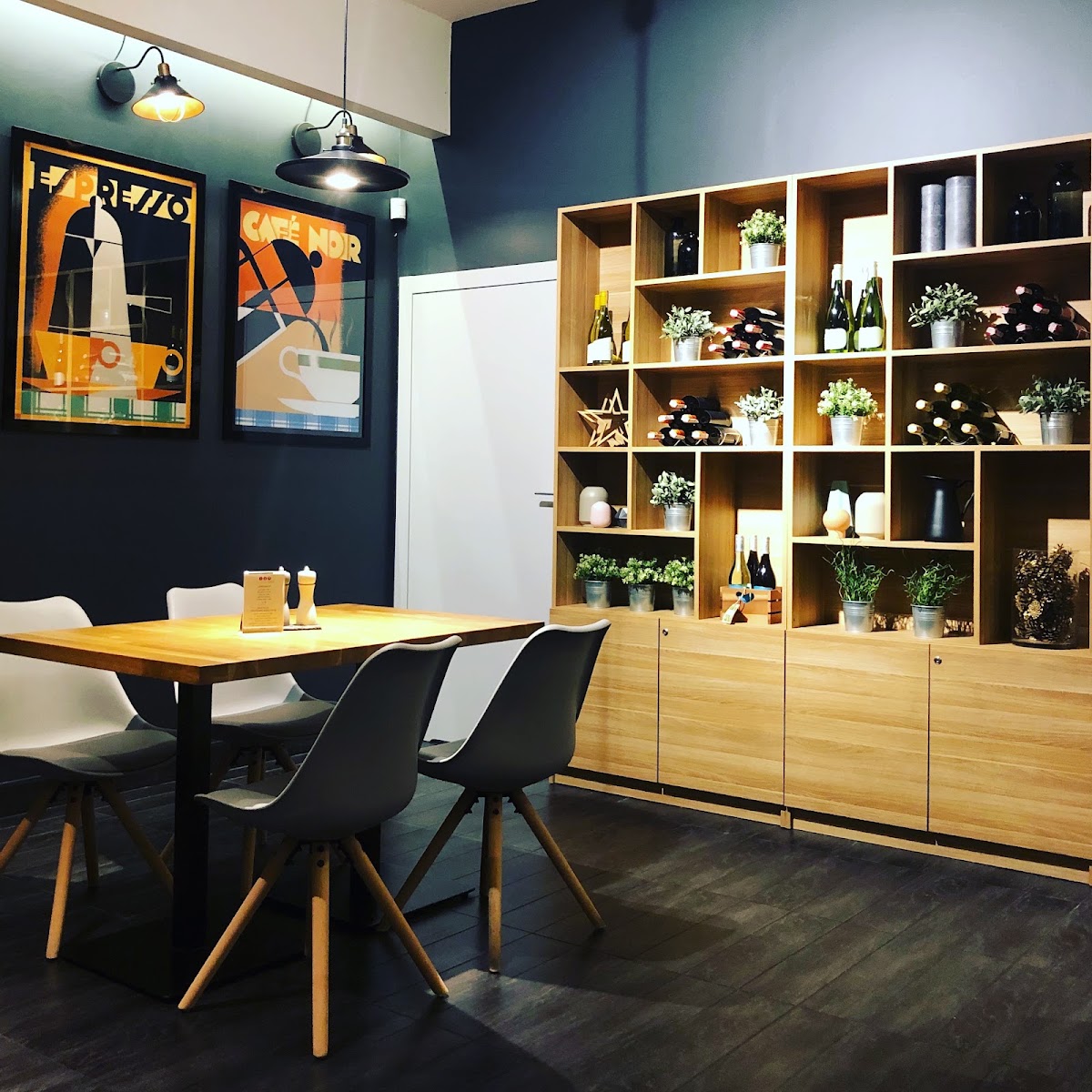 Stoliki i drewniane regały we wnętrzu bistro W Kropki Bordo